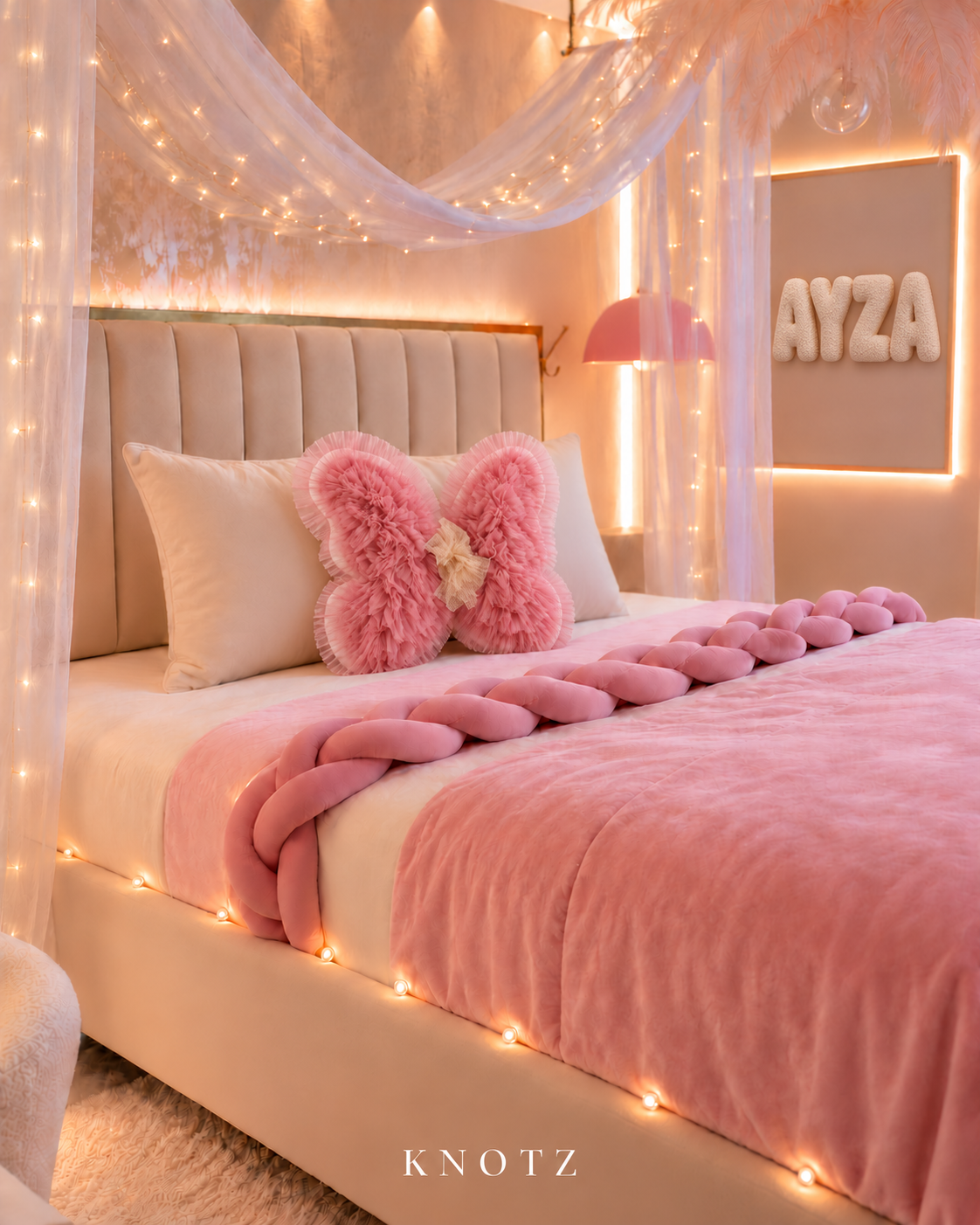 KNOTZ pink and ivory bedroom with one ivory velvet body lumbar pillow, pink layered butterfly cushion, pink velvet braid and ivory bouclé AYZA letters; styled room reference